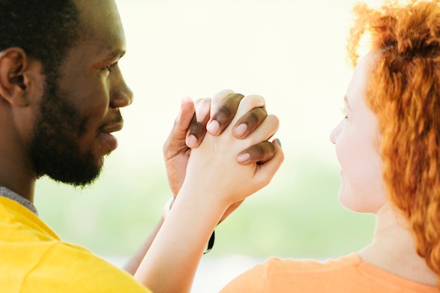 Close-up of interracial couple holding hands