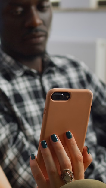 Close up of interracial couple looking at smartphone