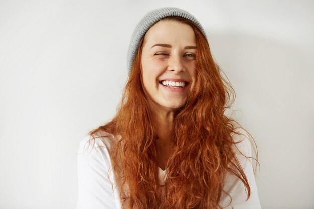 Close up isolated portrait of beautiful redhead girl wearing cap and white T-shirt