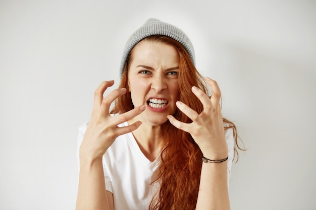 Free photo close up isolated portrait of young annoyed angry woman holding hands in furious gesture