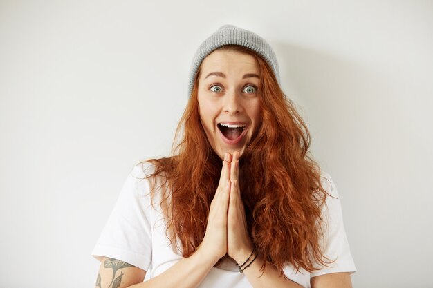 Close up isolated portrait of young female with long loose red hair looking in excitement