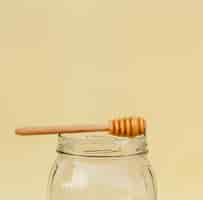 Free photo close-up jar with honey stick on top