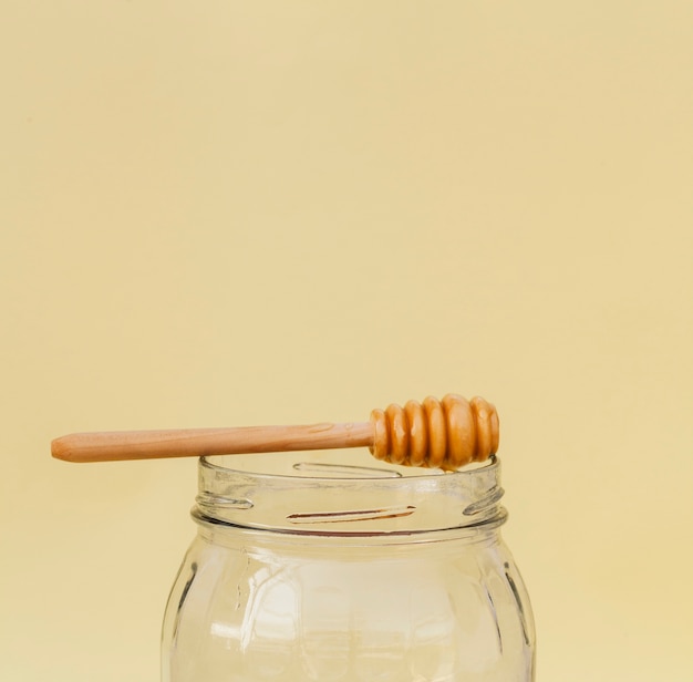 Close-up jar with honey stick on top