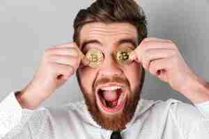 Free photo close up of a joyful businessman with bitcoins in his eyes