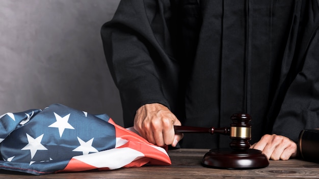 Close-up judge with flag striking the gavel