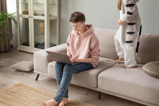 Foto gratuita chiuda sul bambino sul divano e sui genitori che lavorano