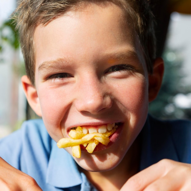 フライドポテトを食べる子供をクローズアップ