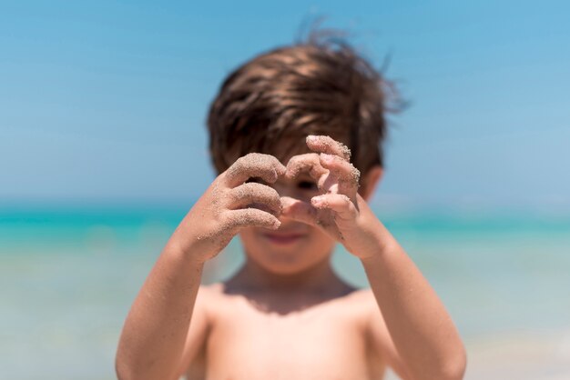 Close up of kid hands playing  at the beach