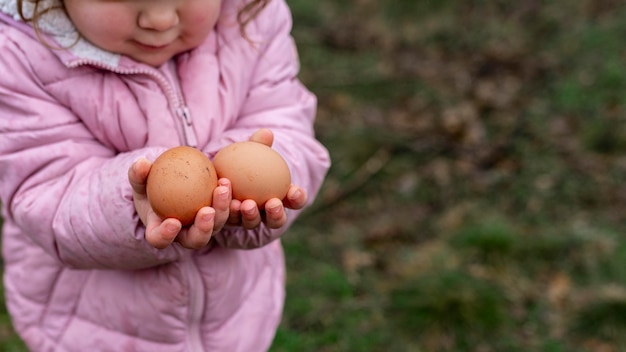 Крупным планом ребенок держит яйца