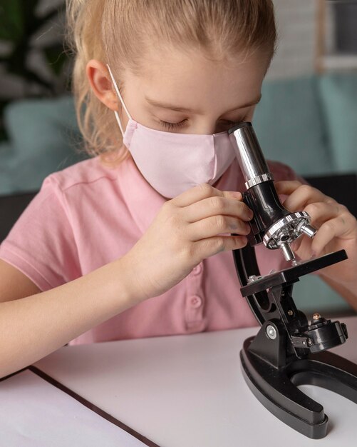 顕微鏡で学習している子供のクローズアップ