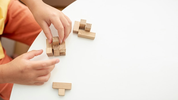 Close-up kid playing with jenga pieces