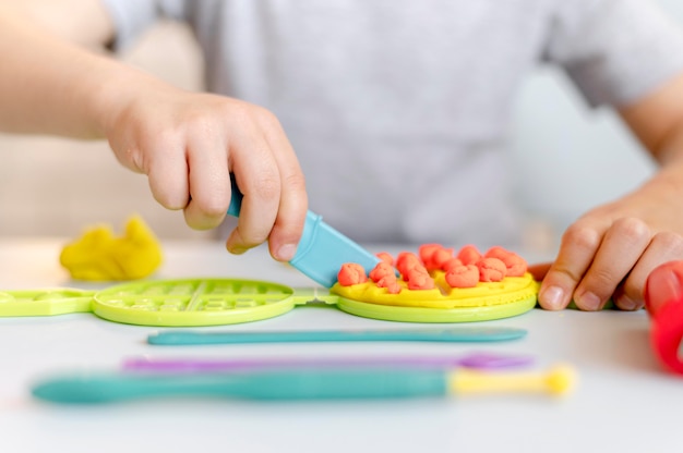 Foto gratuita bambino del primo piano che gioca con il coltello di plastica