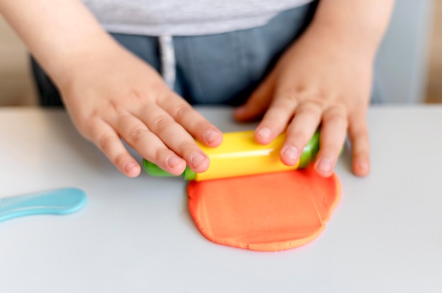 Free photo close-up kid playing with plasticine