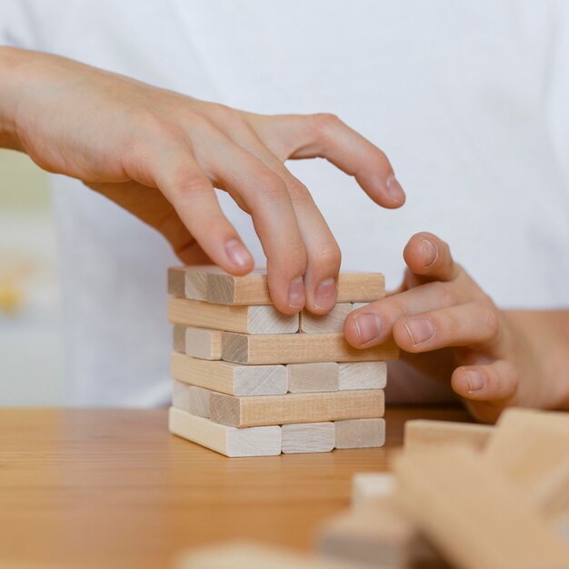 Close-up of kid playing a wooden tower game