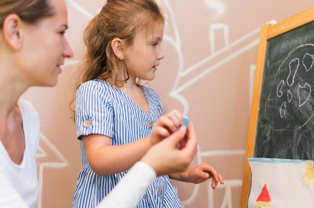 Foto gratuita bambino del primo piano che prende il pezzo di gesso