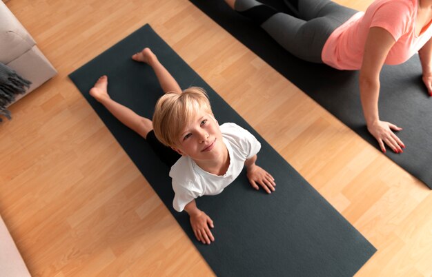 Close up kid and woman with yoga mats