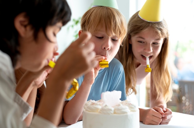 Close up kids celebrating with cake