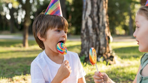 Close-up kids eating lollipops
