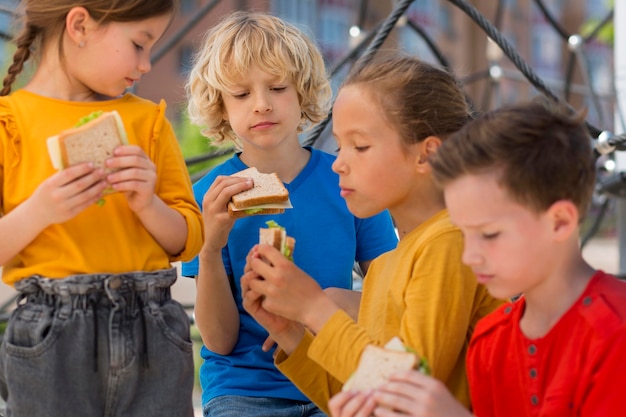 Free photo close up kids eating sandwiches