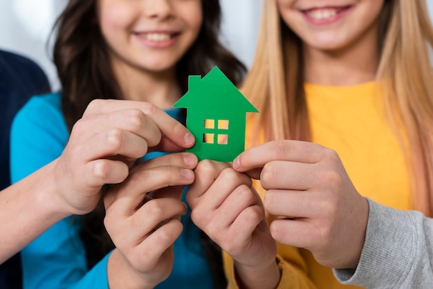 Foto gratuita bambini del primo piano che tengono la casa del giocattolo