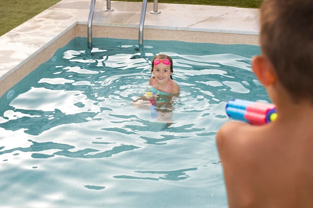 Close up kids playing with water gun