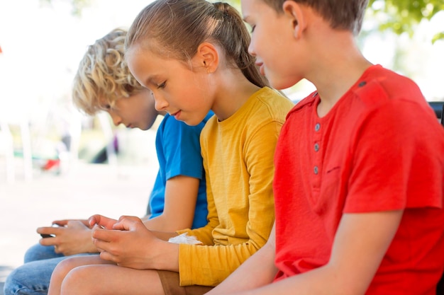 Foto gratuita chiudere i bambini con gli smartphone all'aperto