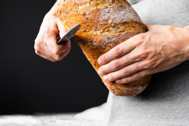 Close-up knife cutting bread loaf