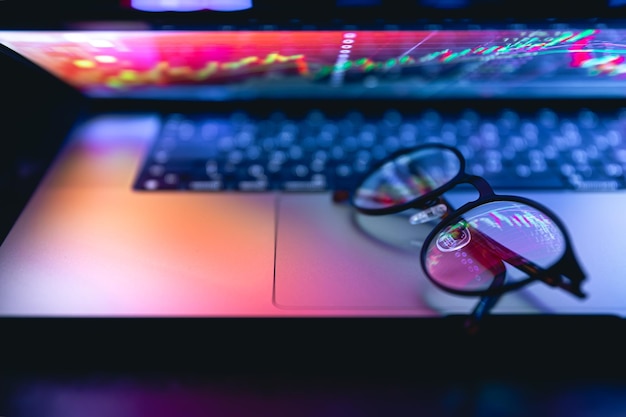 Free photo close up of laptop keyboard colorful neon illumination and eyeglasses