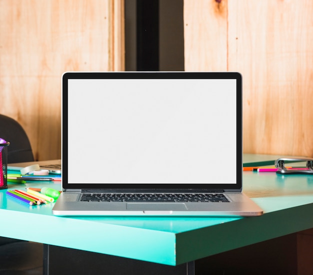테이블 위에 화면에 빈 흰색 디스플레이를 보여주는 노트북의 근접 촬영