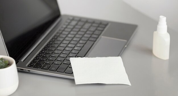 Close-up laptop with disinfectant at the office