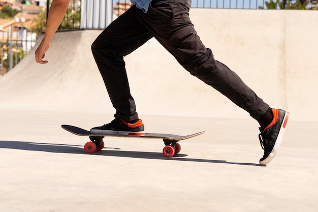 Foto gratuita primo piano della gamba sullo skateboard