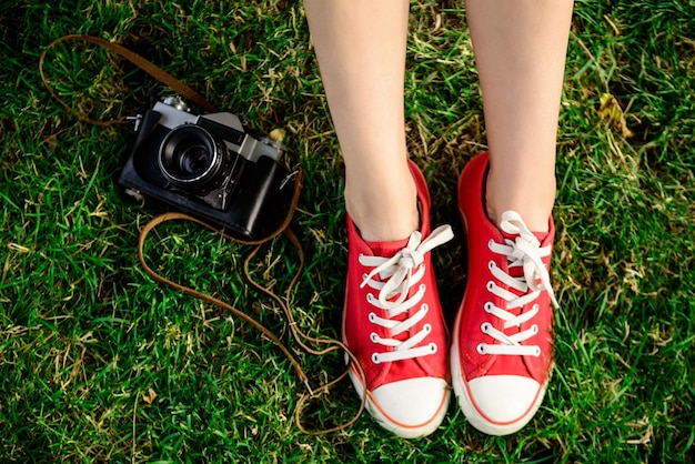 Free photo close up of legs in red keds lying on grass