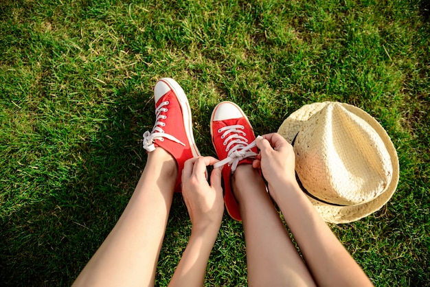 Free photo close up of legs in red keds lying on grass.