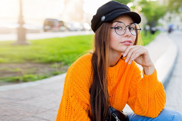 かわいい丸いメガネの物思いに沈んだブルネット白い学生女性のライフスタイルの肖像画を間近します。