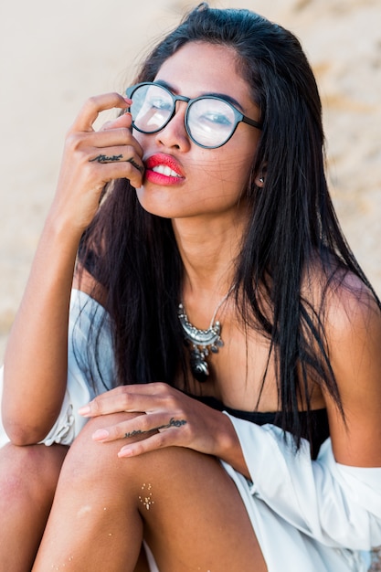 Close up lifestyle portrait of stylish Asian woman with red lips.