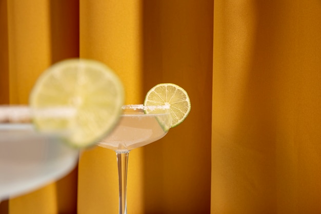 Close-up of lime slices over the edge of margarita cocktail glasses