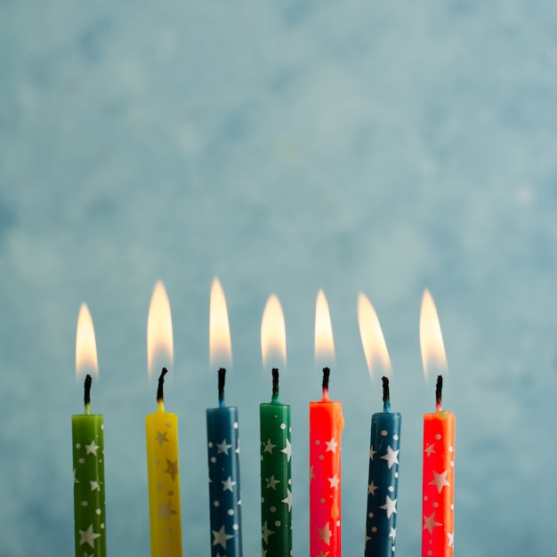 Крупный план зажженных разноцветных свечей на день рождения