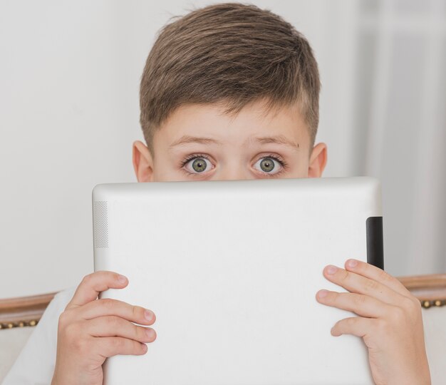 Close-up little boy holding a tablet