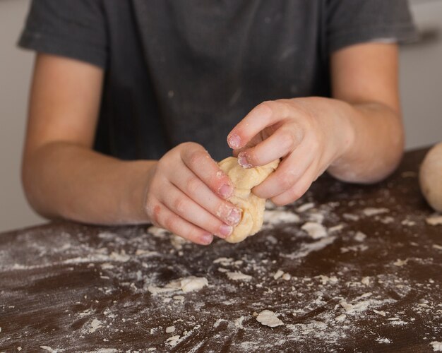Close-up little boy making dough