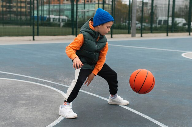 Крупным планом на маленького мальчика, играющего в баскетбол