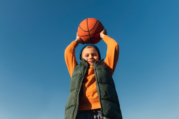 Крупным планом на маленького мальчика, играющего в баскетбол