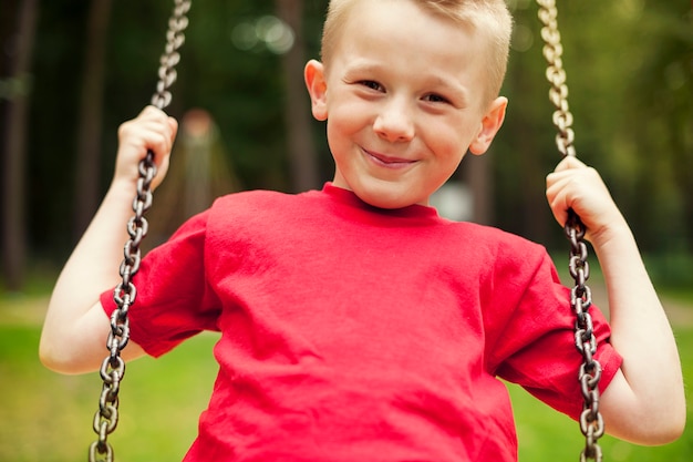 Close-up of little boy swinging