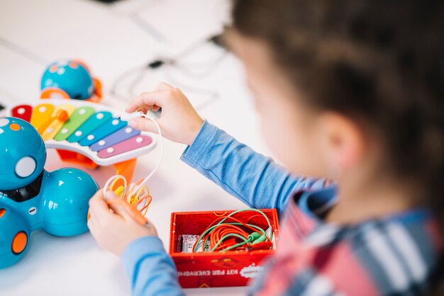 Close-up of a little girl fixing the chord on toy