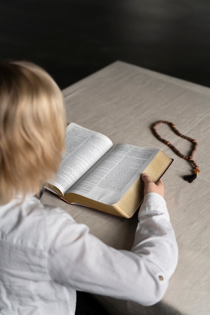 Close up little kid reading bible