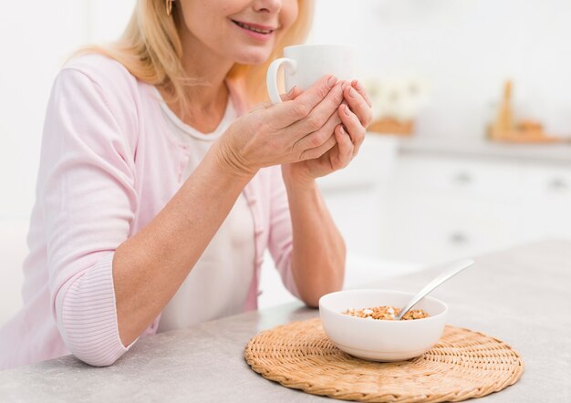 朝食を持っているクローズアップの素敵な年配の女性