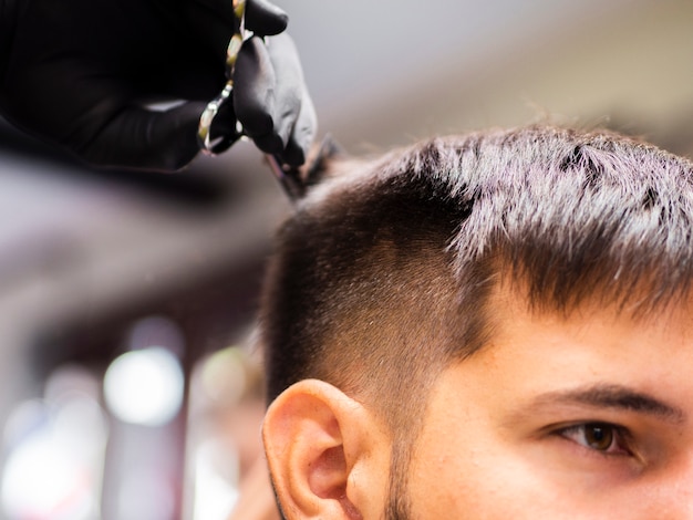 Free photo close-up low view of man getting cut