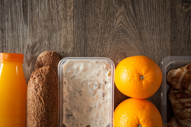 Close up of lunch packed in different boxes. Fresh and healthy eating on wooden background