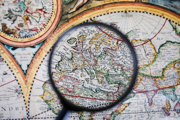 Free photo close-up of magnifying glass over colorful ancient map