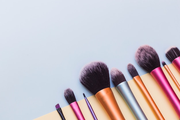 Close-up of makeup brushes on blue backdrop