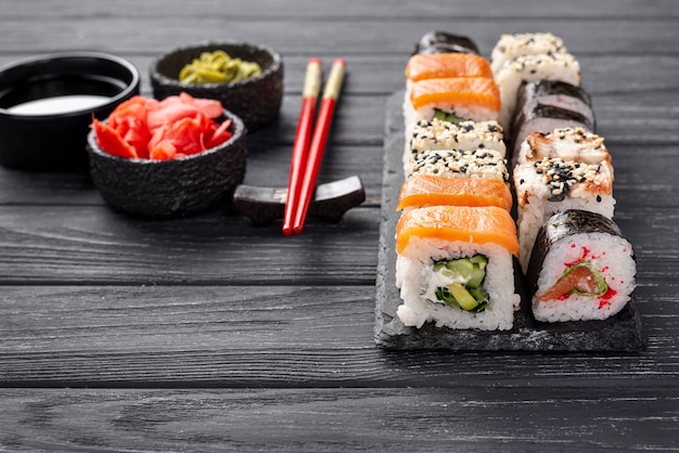 Close-up maki sushi assortment on slate with chopsticks